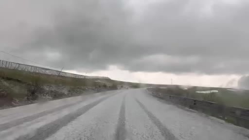 Dolu yağışı sonrası karayolu beyaza büründü