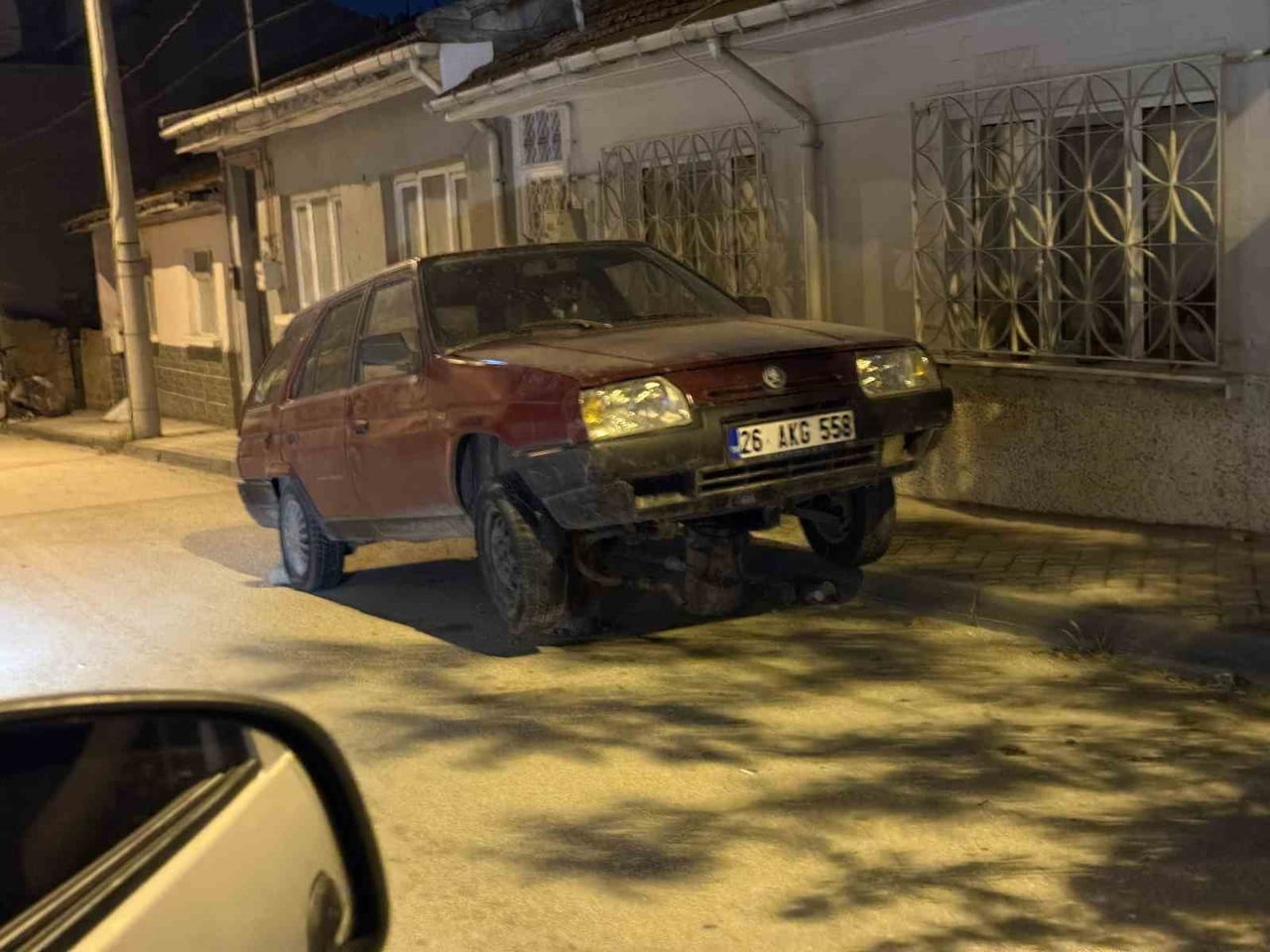 ESKİŞEHİR’DE BİR SOKAKTA, ALTINA İKİ ADET KÜTÜK KONULARAK ÖN TEKERLEKLERİ HAVAYA KALDIRILMIŞ HALDE...