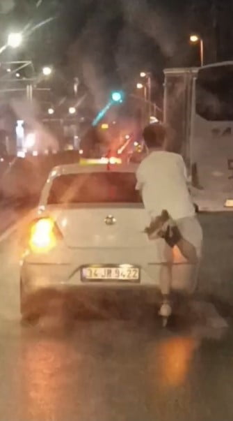 İSTANBUL'UN SULTANGAZİ İLÇESİNDE DÖRTLÜLERİNİ YAKARAK İLERLEYEN OTOMOBİLİN ARKASINA TUTUNAN...