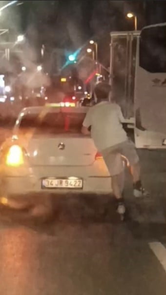 İSTANBUL'UN SULTANGAZİ İLÇESİNDE DÖRTLÜLERİNİ YAKARAK İLERLEYEN OTOMOBİLİN ARKASINA TUTUNAN...