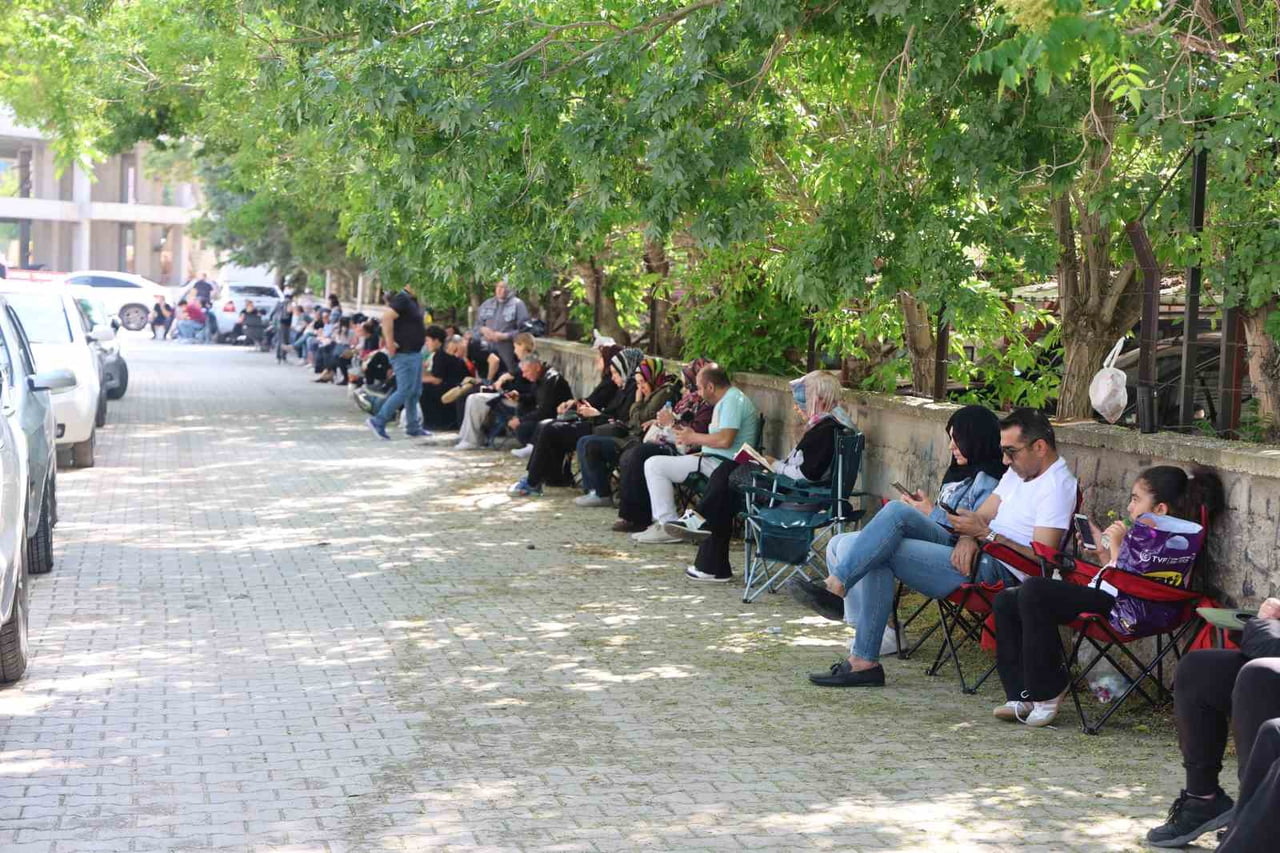 ÖĞRENCİLER SINAVDA TER DÖKERKEN, VELİLER İSE KAMP SANDALYELERİ İLE SOKAKLARI DOLDURDU.