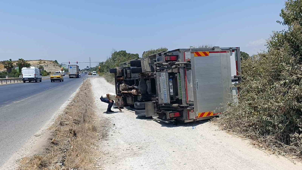 ANTALYA’NIN MANAVGAT İLÇESİNDE ŞARAMPOLE DEVRİLEN KAMYONUN SÜRÜCÜSÜ, YOLDAN GEÇEN VATANDAŞLARIN...
