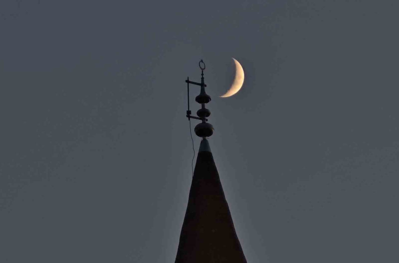BİTLİS'İN AHLAT İLÇESİNDE AKŞAM SAATLERİNDE GÖKYÜZÜNDE BELİREN HİLAL, BİR CAMİNİN MİNARESİNDEKİ...