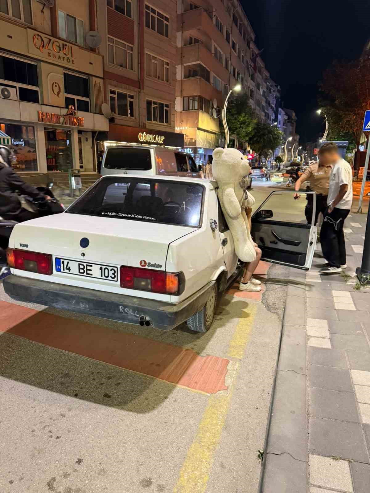 BOLU’DA ARKA CAMINA SARKITILMIŞ PELUŞ AYIYLA TRAFİKTE SEYREDEN OTOMOBİL, GECE BEKÇİLERİNİN...