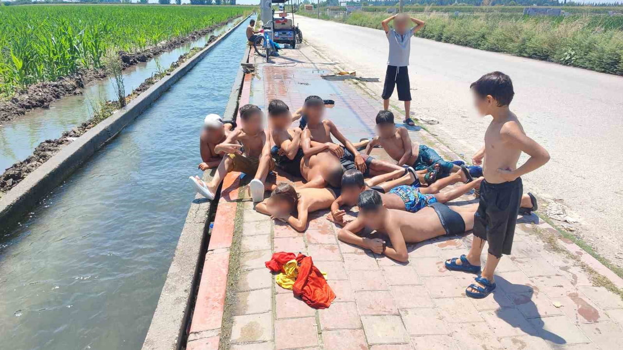 ÇOCUKLARIN KANAL KENARINDAKİ KALDIRIMDA GÜNEŞLENMESİ İSE İLGİNÇ GÖRÜNTÜLER OLUŞTURDU.