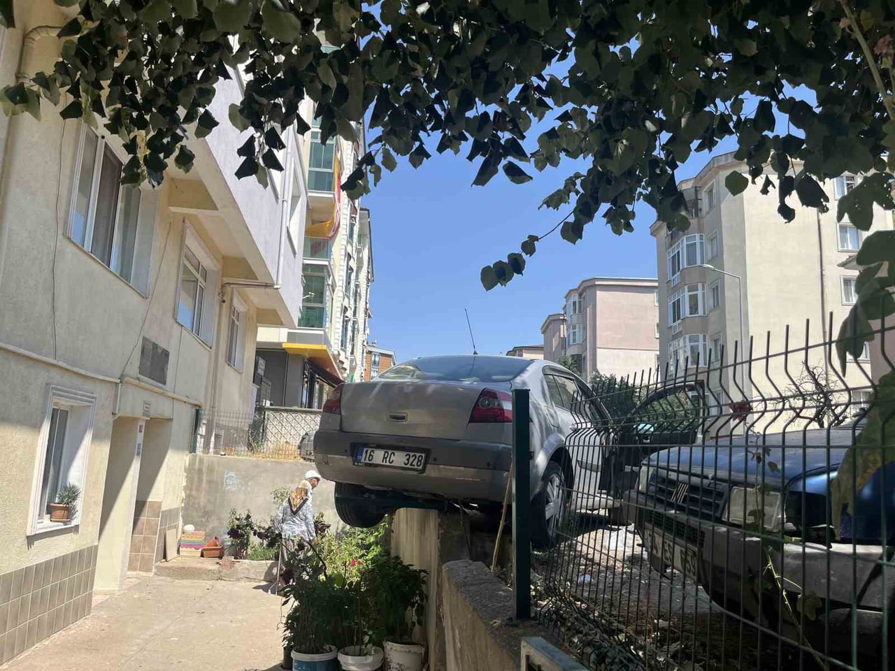 EL FRENİ ÇEKİLMEYİ UNUTULAN OTOMOBİL, BAHÇE DUVARINDA ASILI KALDI: O ANLAR KAMERADA