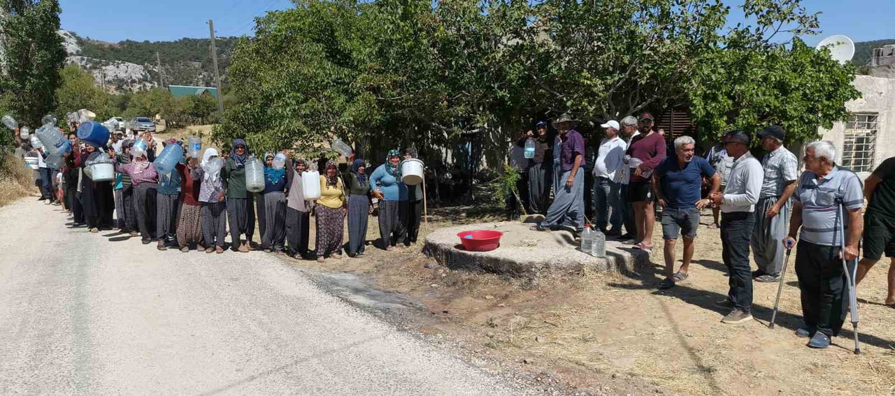 ELLERİNDE SU BİDONLARI OLAN VATANDAŞLAR