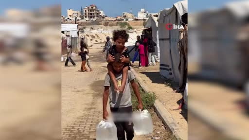 Gazze'de İsrail'in saldırılarına rağmen hayatta kalmaya çalışan Filistinli çocuk, iki elinde su...