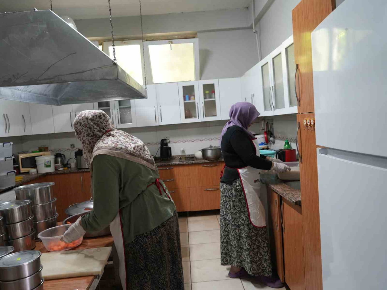 HATİCE BELTEKOĞLU VE FATMA DUMAN BİRLİKTE YEMEKLER YAPIYORLAR.