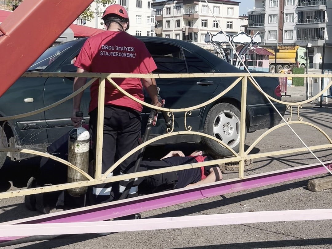 İTFAİYE EKİPLERİNİN OTOMOBİLİN ALTINA GİRMEK İÇİN ÇALIŞMA BAŞLATMASI