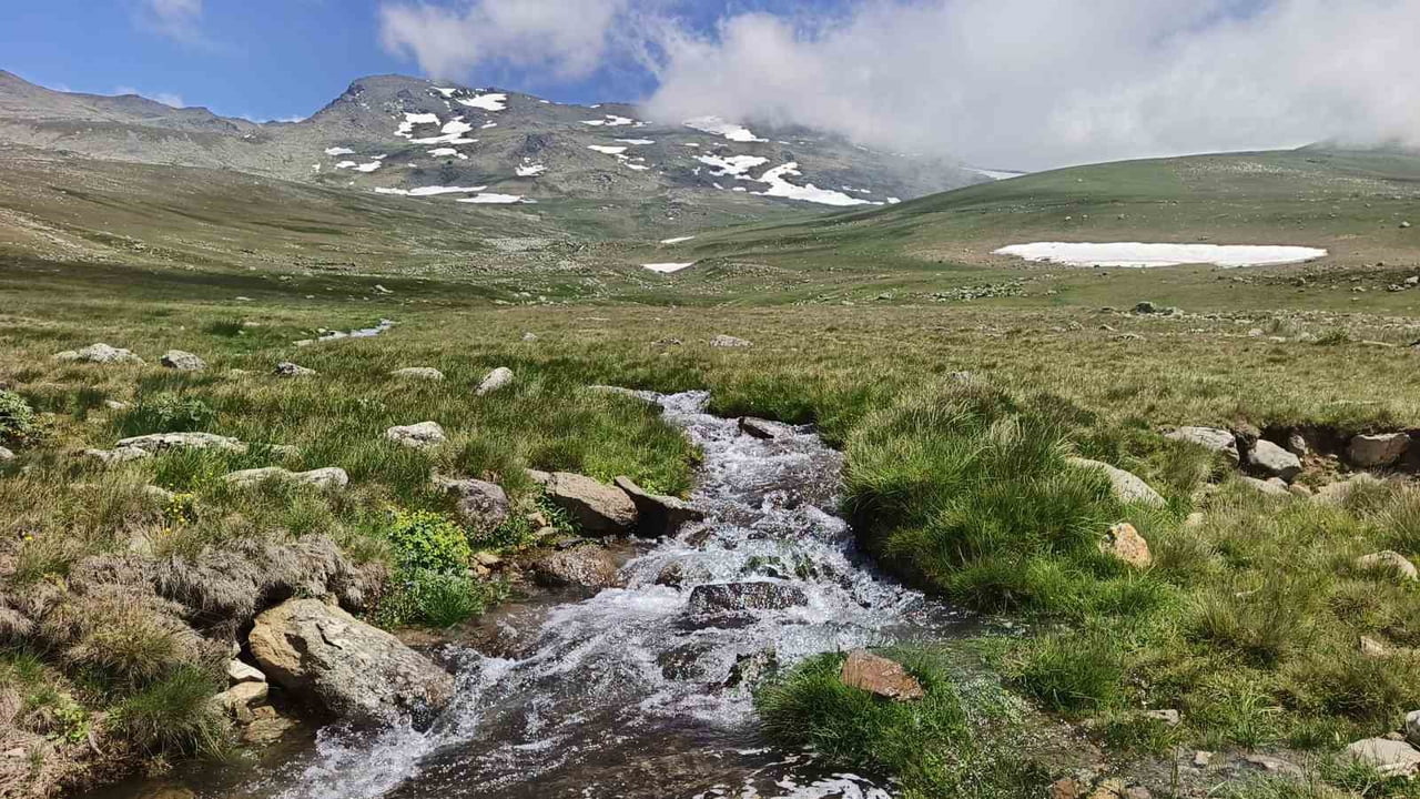 KARLI DAĞLAR VE YEŞİL ÇİMENLERİN ARASINDAN AKAN SULAR