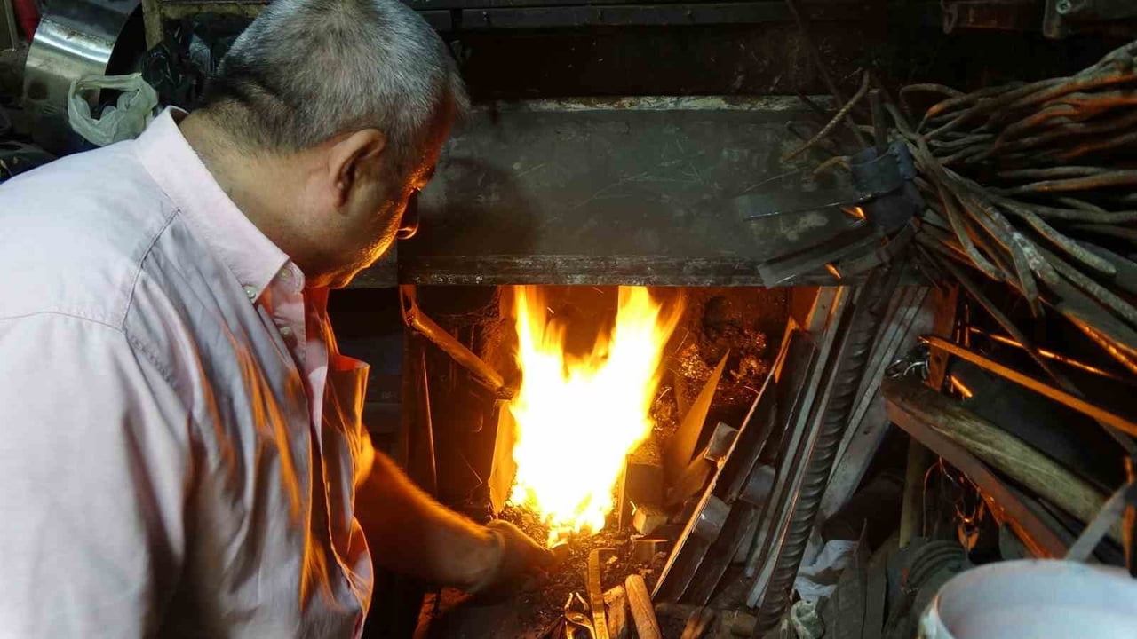 KİLİS'TE KAVURUCU YAZ SICAKLARINDA ATEŞİN KARŞISINA GEÇEN DEMİRCİ USTASI, BİN DERECEYİ BULAN OCAK...