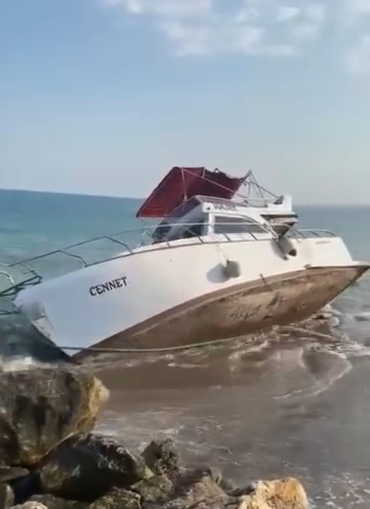 MERSİN'DE DENİZDE MOTORU ARIZALANAN TEKNE KIYIYA VURDU, ÇEKİLİRKEN İSE KISMEN BATTI.