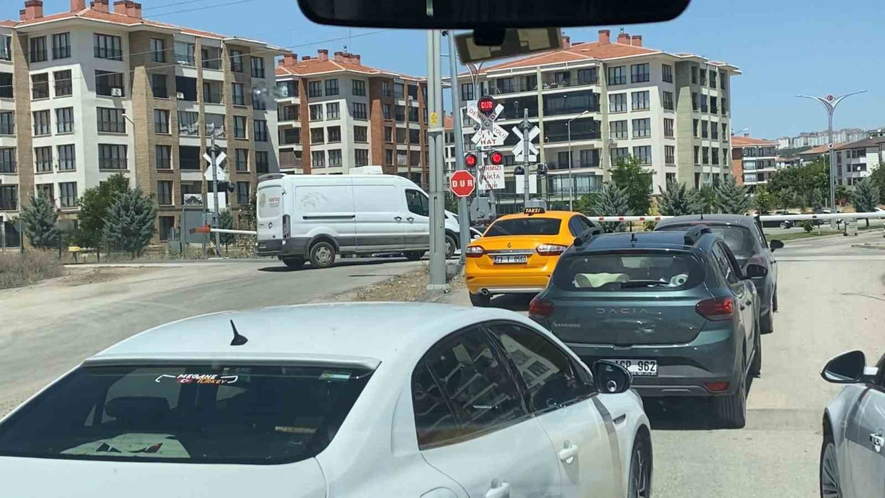 TRENİN GEÇİŞİNDEN DOLAYI HEMZEMİN GEÇİTTE BULUNAN BARİYERLER KAPANDI. BİR SÜRE BEKLEYEN...