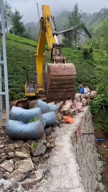 RİZE'DE DİK VE ENGEBELİ ARAZİDE ÇAY HASADI YAPAN BİR ÜRETİCİ, TOPLADIĞI ÇAY BEZLERİNİ TAŞIMAK İÇİN...