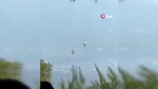 Yunanistan’da orman yangınlarıyla mücadele sırasında iki yangın söndürme helikopteri havada...