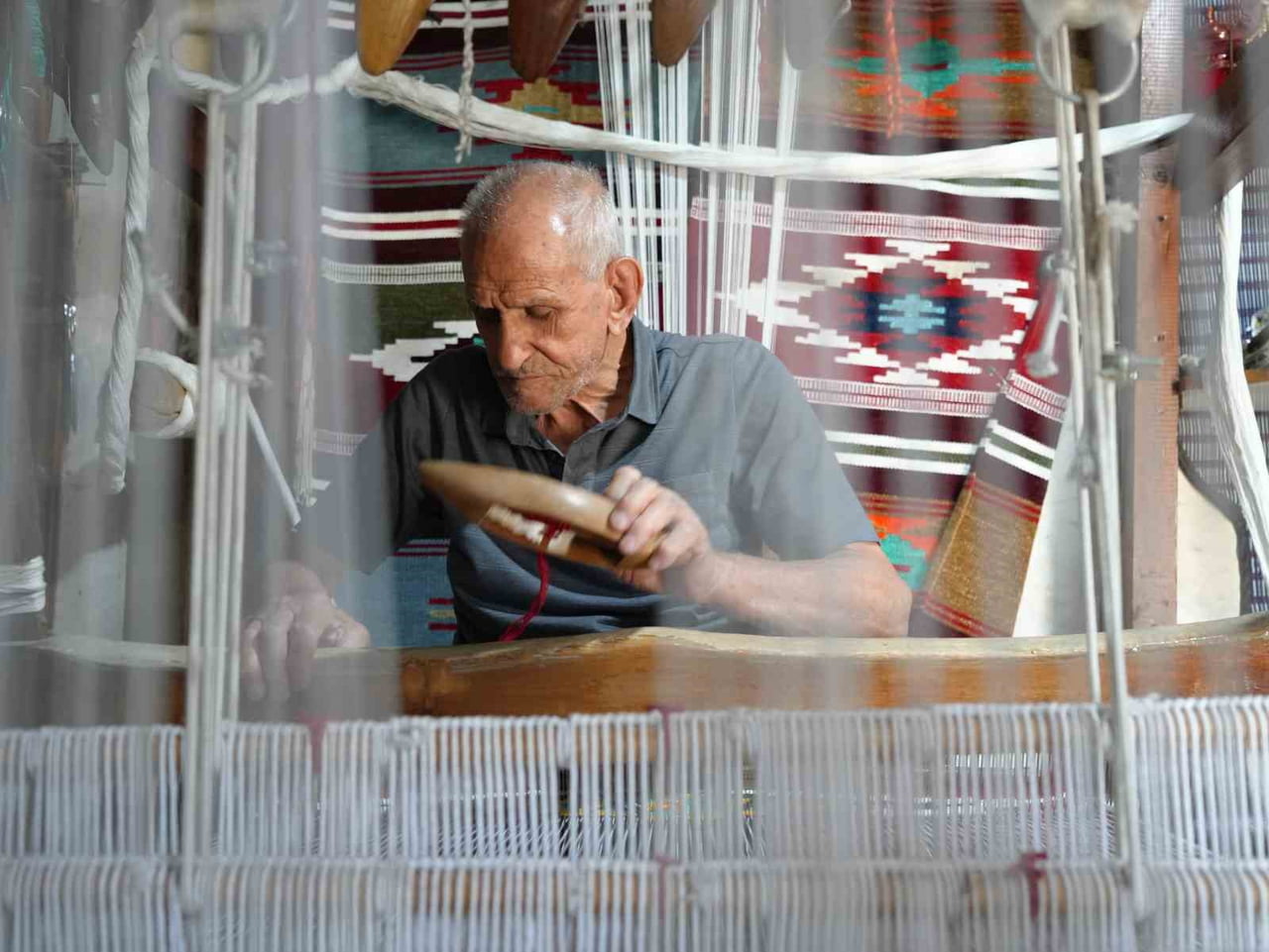 3 METREKARELİK DÜKKANINDA DOKUDUĞU KİLİMLERİ DÜNYAYA GÖNDERİYOR