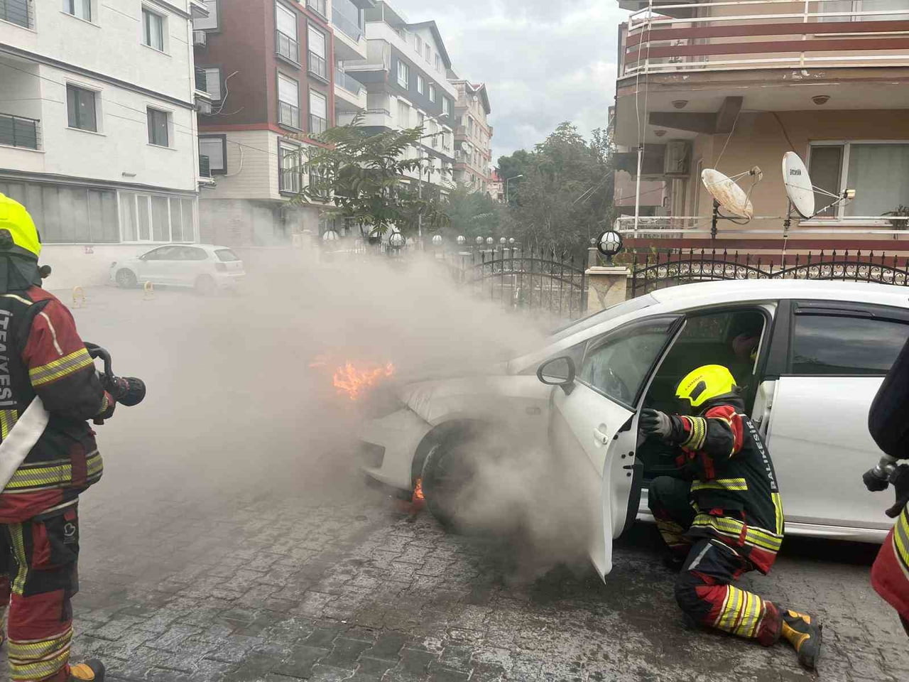 BALIKESİR’İN BURHANİYE İLÇESİNDE CADDE ÜZERİNDE ANİDEN ALEV ALAN OTOMOBİL, İTFAİYE EKİPLERİNİN...