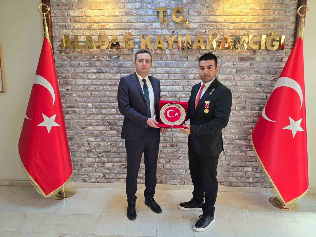 GAZİ ERDEM DURNA, OLAY GÜNÜ ALADAĞ KAYMAKAMLIĞI'NDA DÜZENLENEN GAZİLER GÜNÜ PROGRAMINDA PLAKET...