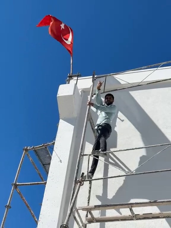 RÜZGÂR NEDENİYLE TERS DÖNEN TÜRK BAYRAĞINI DÜZELTMEK İÇİN YAKLAŞIK 10 METRE YÜKSEKLİĞİNDEKİ İNŞAAT...
